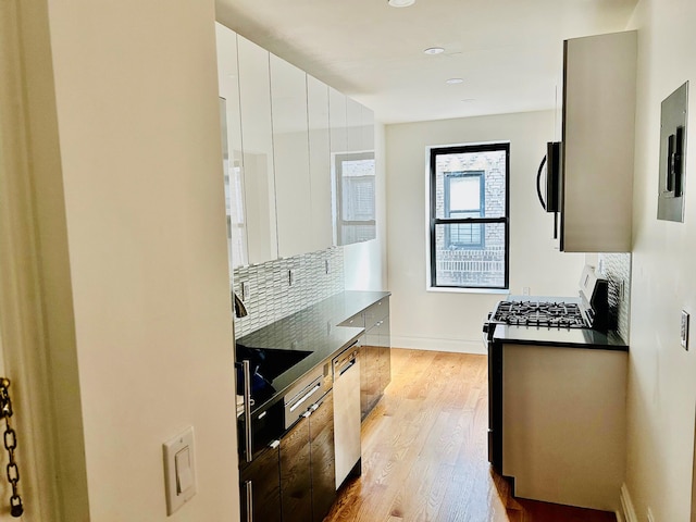 kitchen with white cabinetry, light hardwood / wood-style flooring, stainless steel dishwasher, backsplash, and gas stove