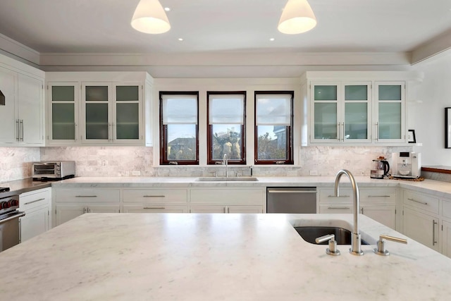 kitchen featuring white cabinetry, sink, hanging light fixtures, and stainless steel dishwasher