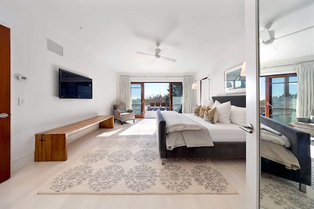 bedroom featuring ceiling fan, access to outside, multiple windows, and light hardwood / wood-style flooring