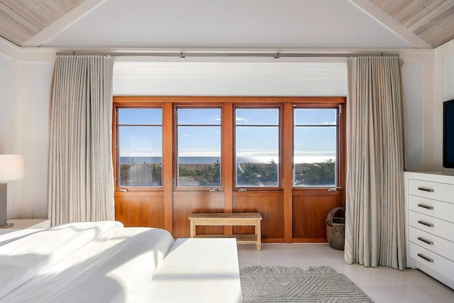 bedroom featuring vaulted ceiling and wood walls