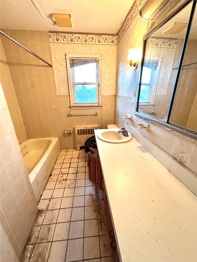 bathroom with tile walls, tile patterned flooring, radiator heating unit, and vanity