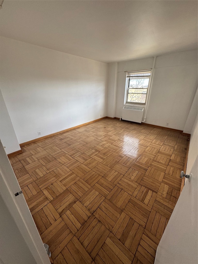 spare room with light parquet flooring and radiator heating unit