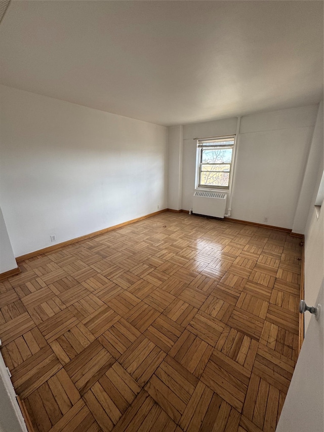 spare room with light parquet flooring and radiator