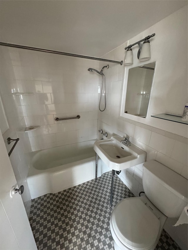 full bathroom with tasteful backsplash, sink, tile walls, tiled shower / bath combo, and toilet