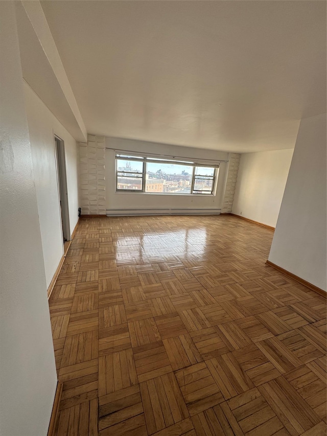 spare room featuring light parquet floors and baseboard heating