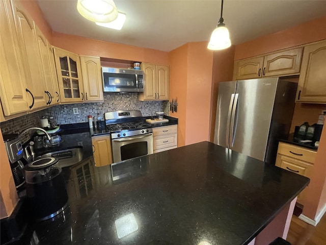 kitchen with appliances with stainless steel finishes, hanging light fixtures, light brown cabinetry, sink, and tasteful backsplash