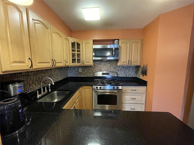 kitchen featuring stainless steel appliances, light brown cabinetry, sink, and tasteful backsplash