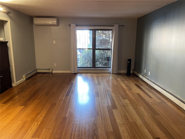 unfurnished room featuring an AC wall unit, baseboard heating, and hardwood / wood-style flooring