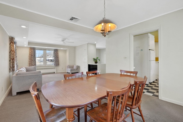 carpeted dining area featuring ceiling fan and radiator heating unit