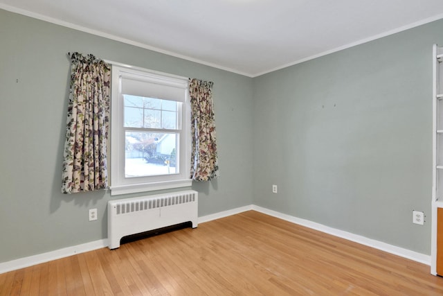 unfurnished room with crown molding, radiator heating unit, and light hardwood / wood-style flooring