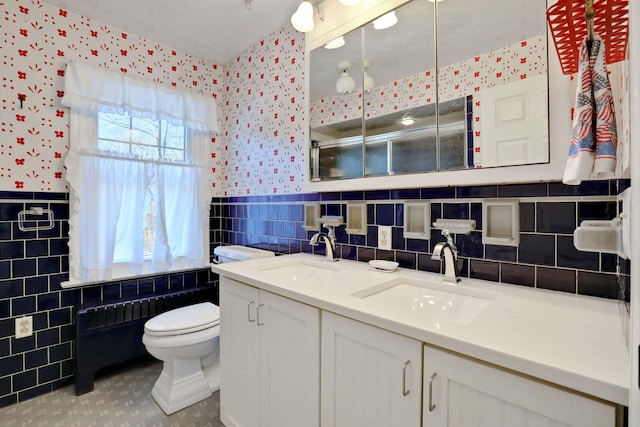 bathroom featuring tile walls, vanity, toilet, and an enclosed shower