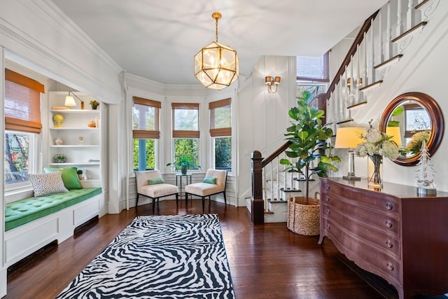 sitting room featuring built in features, dark hardwood / wood-style flooring, a wealth of natural light, and a notable chandelier