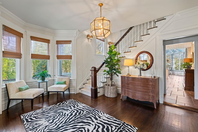 living area featuring wood-type flooring, a notable chandelier, and a healthy amount of sunlight