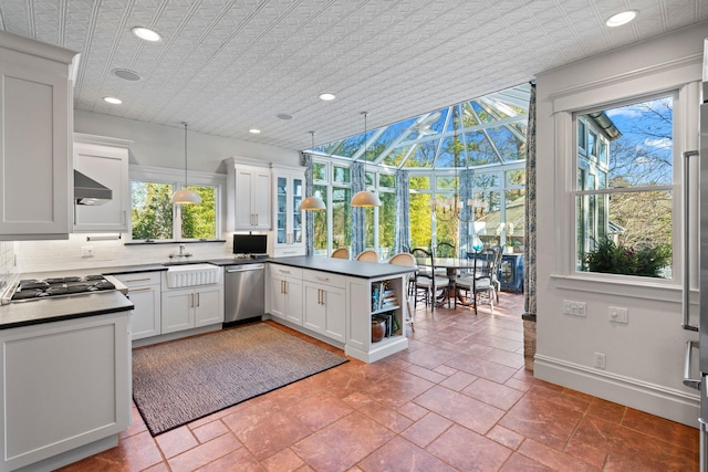 kitchen featuring appliances with stainless steel finishes, plenty of natural light, white cabinetry, and pendant lighting