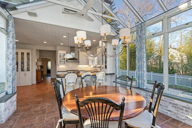 dining room featuring ceiling fan with notable chandelier and a towering ceiling