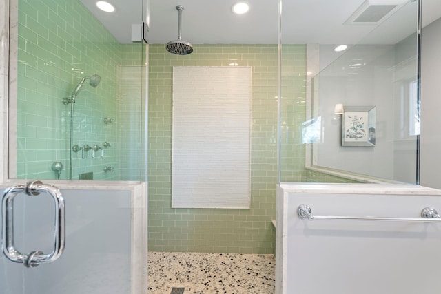 bathroom featuring a shower with shower door and tile walls