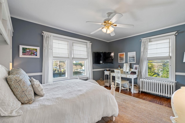 bedroom featuring radiator, ceiling fan, dark hardwood / wood-style flooring, and multiple windows