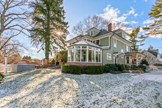 back of house with a swimming pool and a sunroom