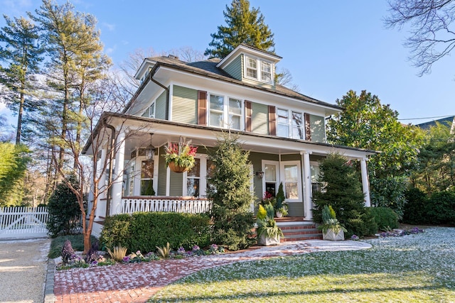 view of front of house with a front yard and covered porch