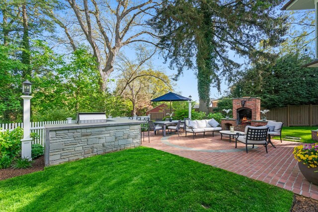 view of yard featuring area for grilling, a patio, and an outdoor living space with a fireplace