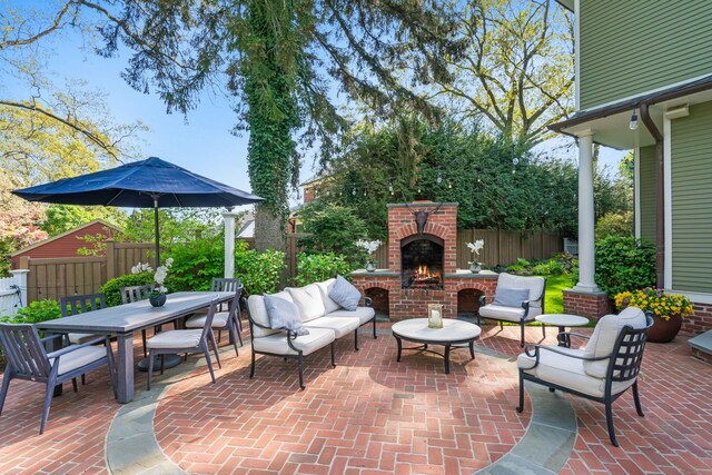 view of patio featuring fence, an outdoor living space with a fireplace, and outdoor dining area