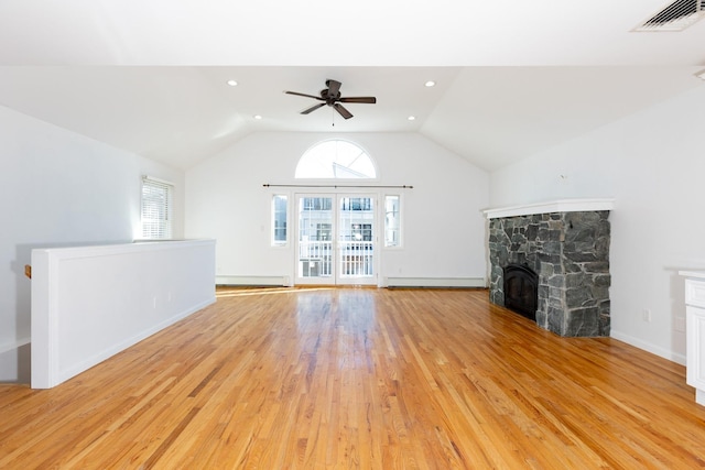 unfurnished living room with lofted ceiling, light hardwood / wood-style flooring, a healthy amount of sunlight, and a fireplace