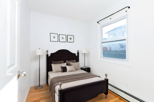 bedroom featuring light hardwood / wood-style floors and a baseboard radiator