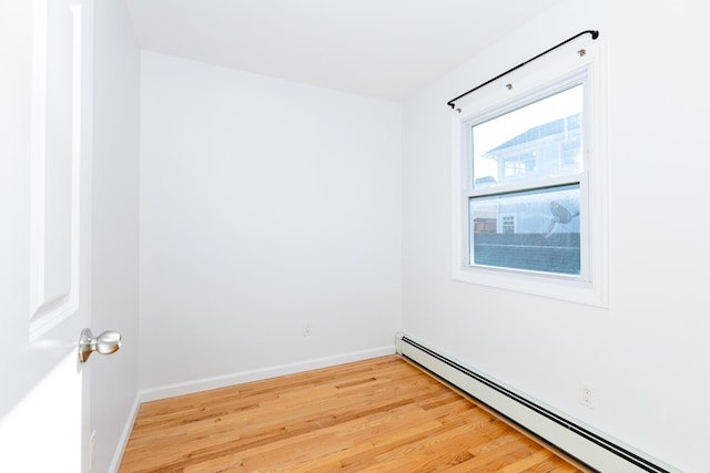 spare room featuring light wood-type flooring and a baseboard heating unit