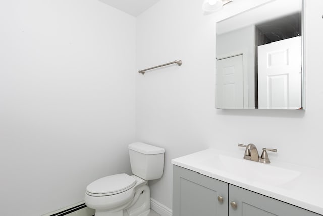 bathroom featuring toilet, vanity, and a baseboard heating unit