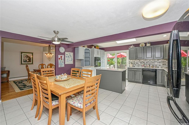 tiled dining room with ceiling fan and a baseboard radiator