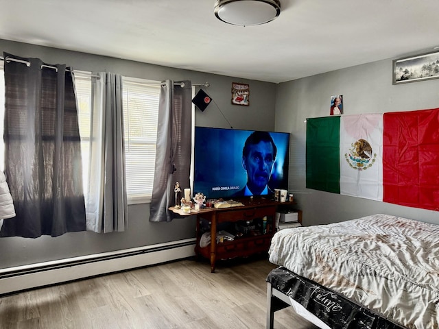 bedroom featuring baseboard heating and wood-type flooring