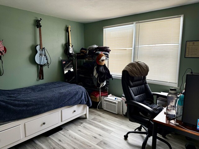 bedroom with multiple windows and light hardwood / wood-style flooring