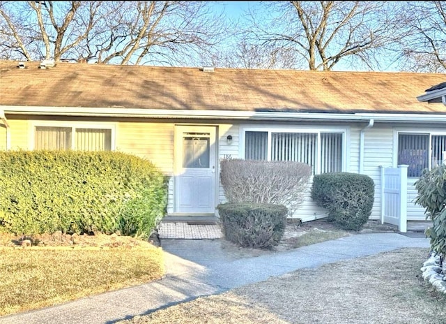 entrance to property featuring roof with shingles