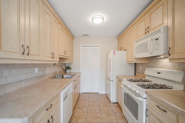 kitchen with visible vents, light brown cabinetry, light tile patterned floors, white appliances, and a sink