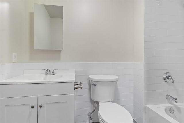 full bathroom featuring toilet, vanity, tile walls, and  shower combination