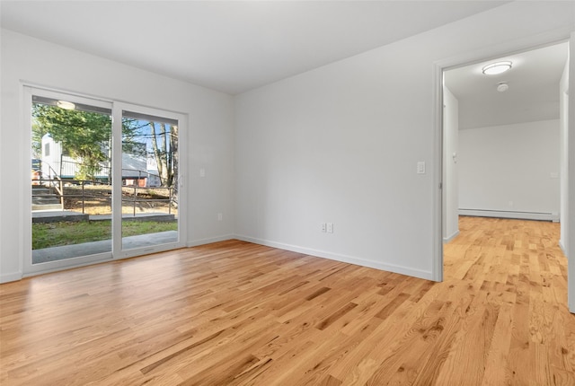 empty room featuring light hardwood / wood-style floors and baseboard heating