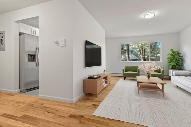 living room with baseboards, baseboard heating, and light wood-style floors