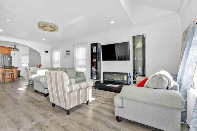 living room with ornamental molding and light hardwood / wood-style floors