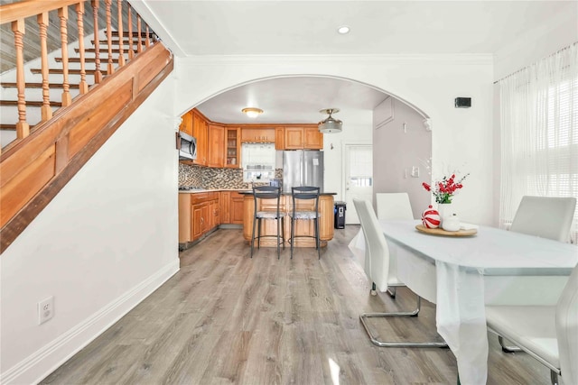 dining room featuring crown molding and light hardwood / wood-style flooring