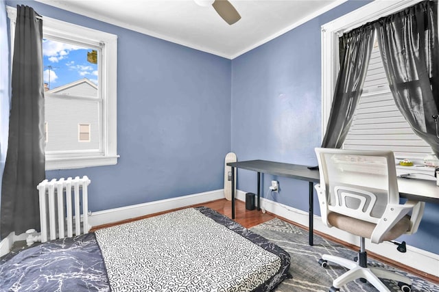 bedroom featuring radiator, dark wood-type flooring, ornamental molding, and ceiling fan