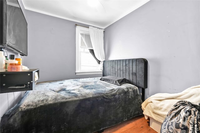 bedroom featuring hardwood / wood-style flooring and ornamental molding