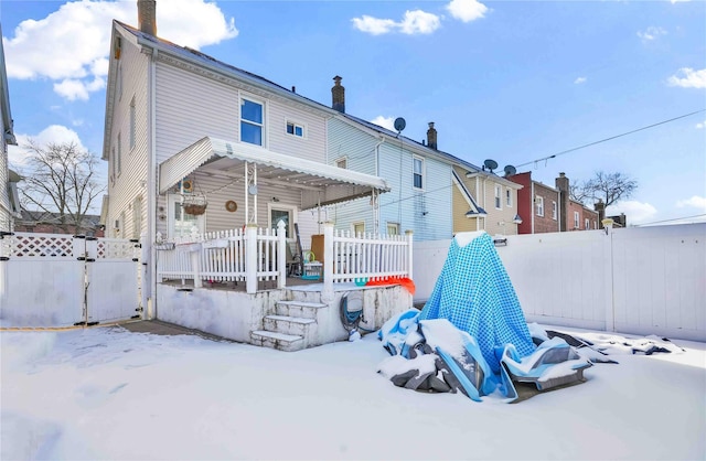 view of snow covered back of property