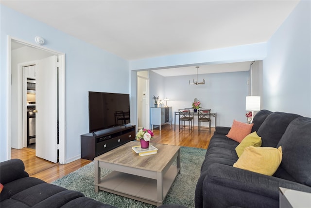 living room with hardwood / wood-style floors and a notable chandelier