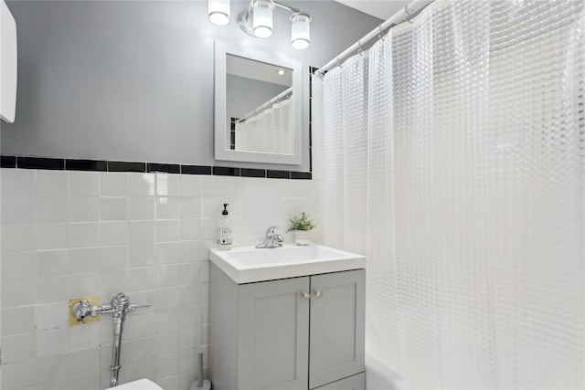 bathroom with vanity, curtained shower, and tile walls