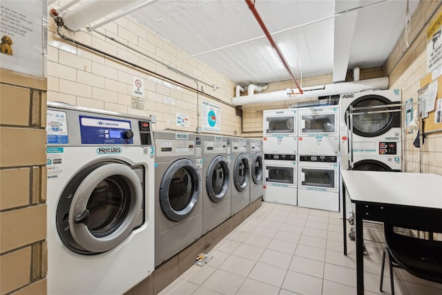 washroom with stacked washer / drying machine, washer and dryer, and light tile patterned flooring