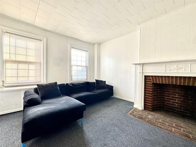 living room with wooden walls, radiator heating unit, and dark colored carpet