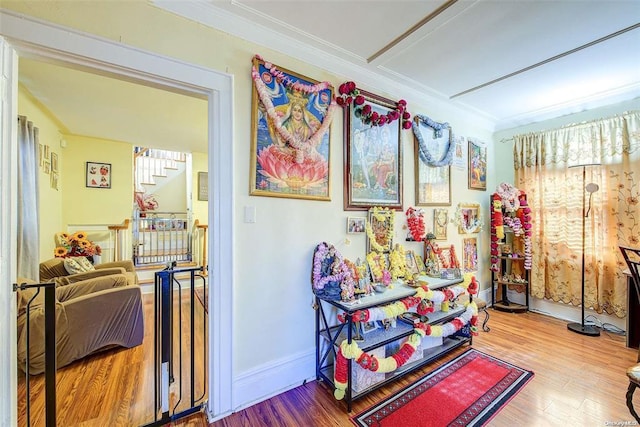 recreation room featuring hardwood / wood-style flooring and ornamental molding