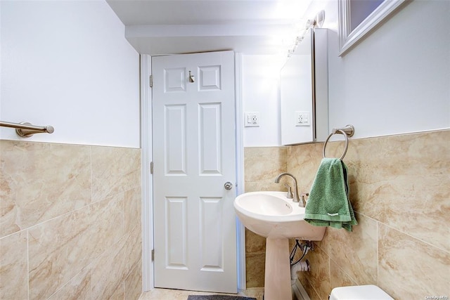 bathroom featuring toilet and tile walls