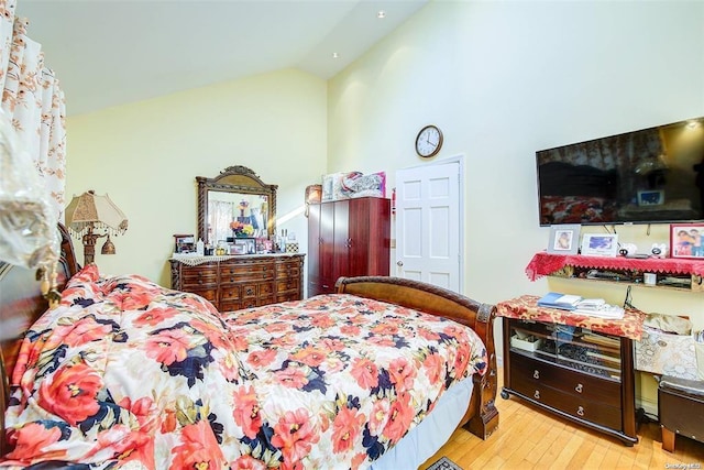 bedroom featuring light hardwood / wood-style floors and lofted ceiling