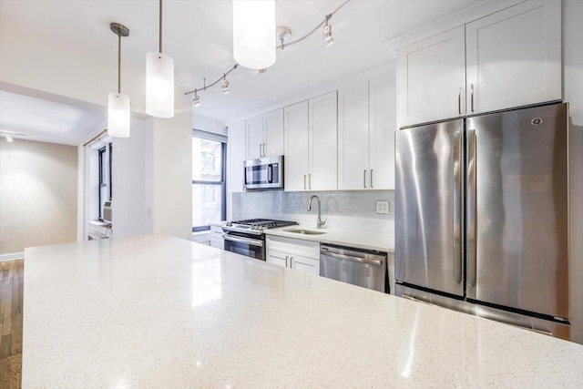 kitchen with light stone countertops, white cabinetry, and appliances with stainless steel finishes